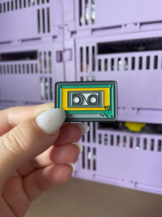 Cute Cassette Retro Enamel Pin - A charming enamel pin featuring a cute and smiling cassette tape, perfect for music lovers and fans of all things retro.